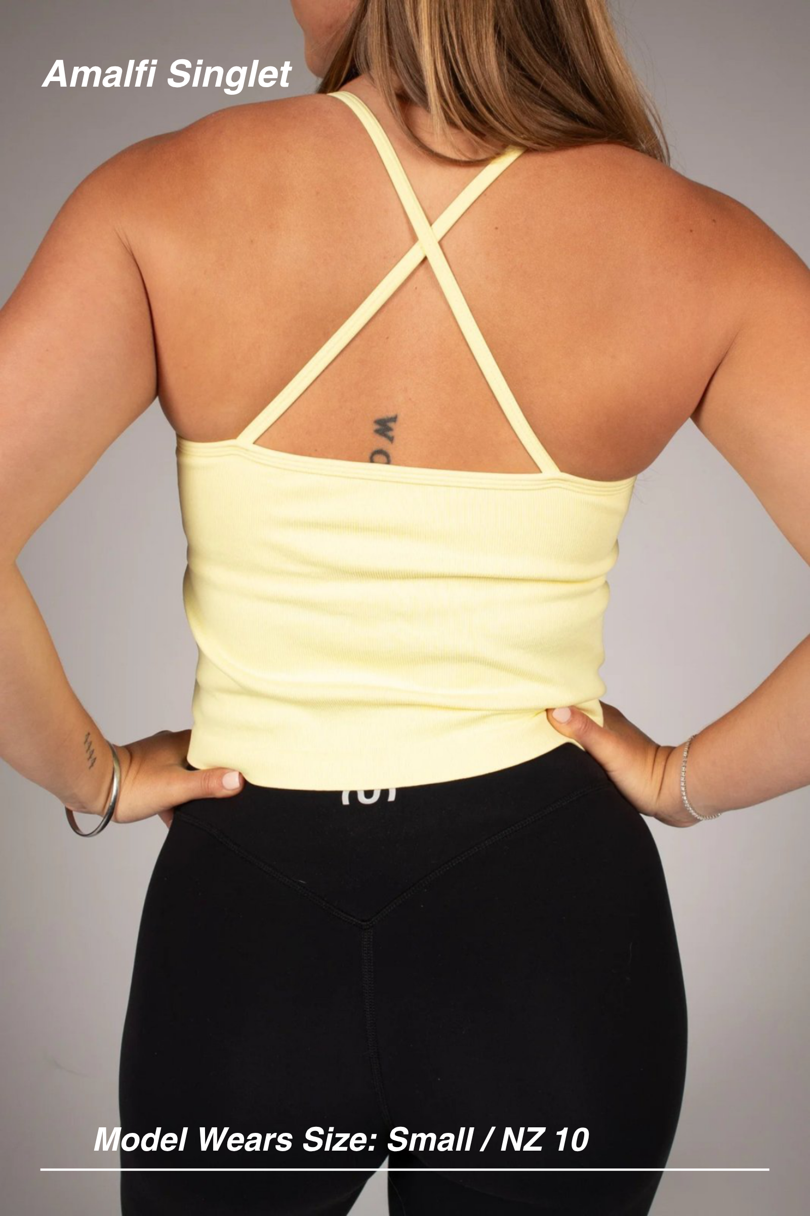 Mint Activewear Amalfi singlet in yellow, back view showing cross-back straps, with black leggings