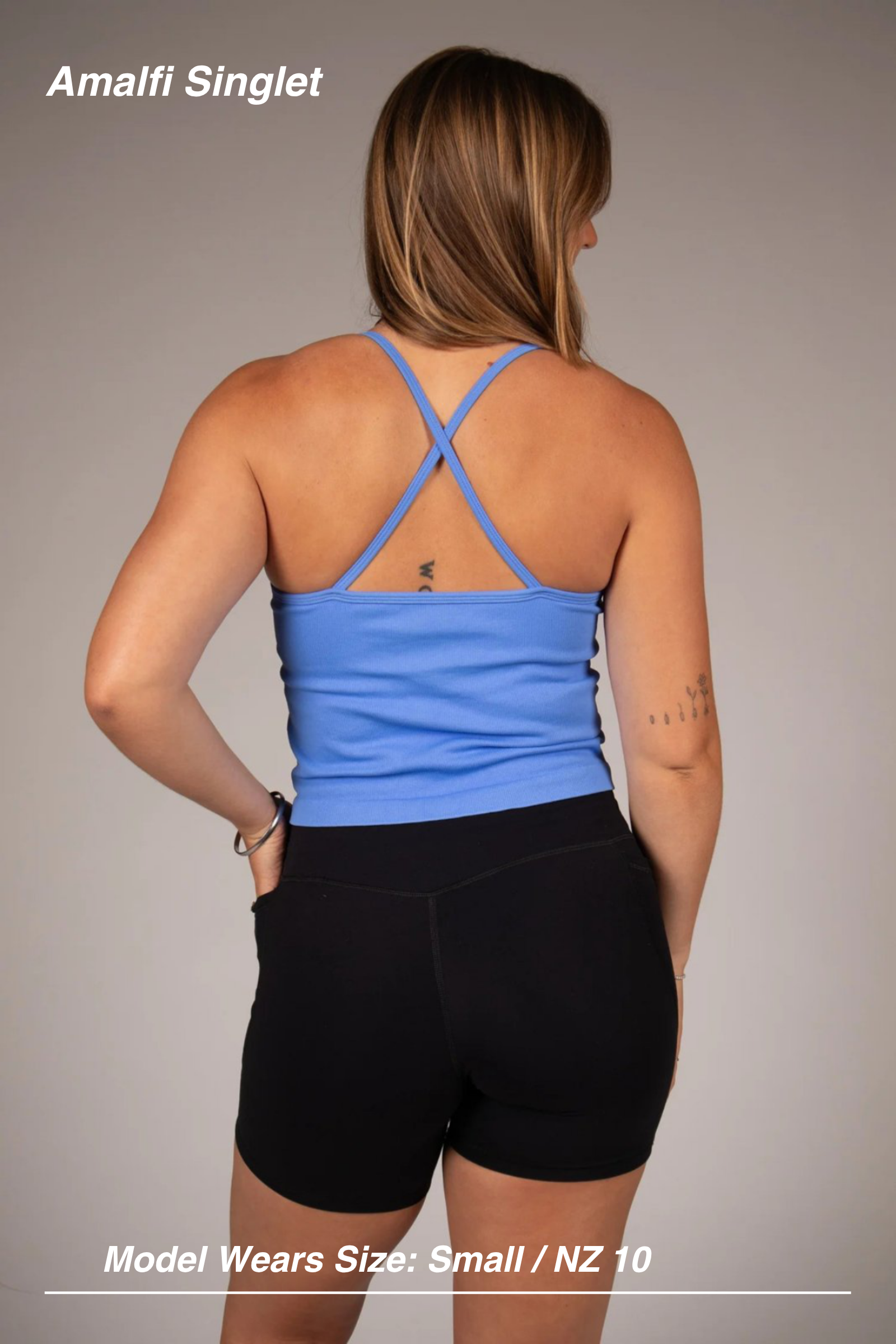 Mint Activewear Amalfi singlet in blue, back view showing cross-back straps, with black shorts