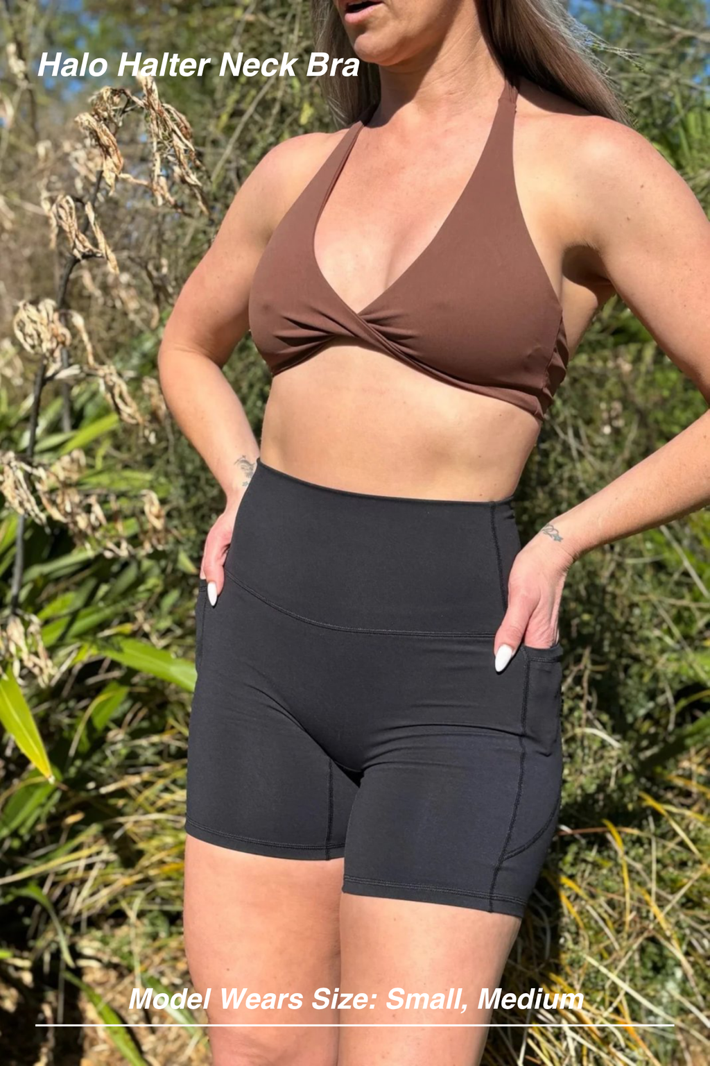 Mint Activewear Halo Halter Neck Bra in brown, front view styled with black shorts in an outdoor setting.