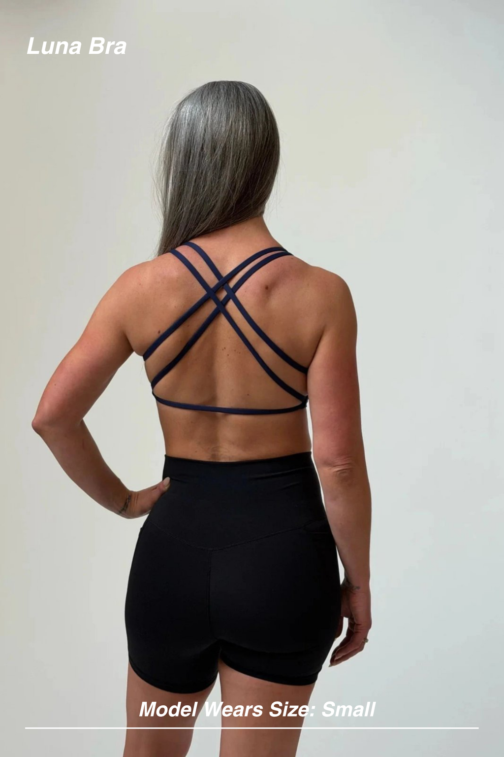 Mint Activewear Luna Bra in navy, back view showing the layered crossed strappy back design.