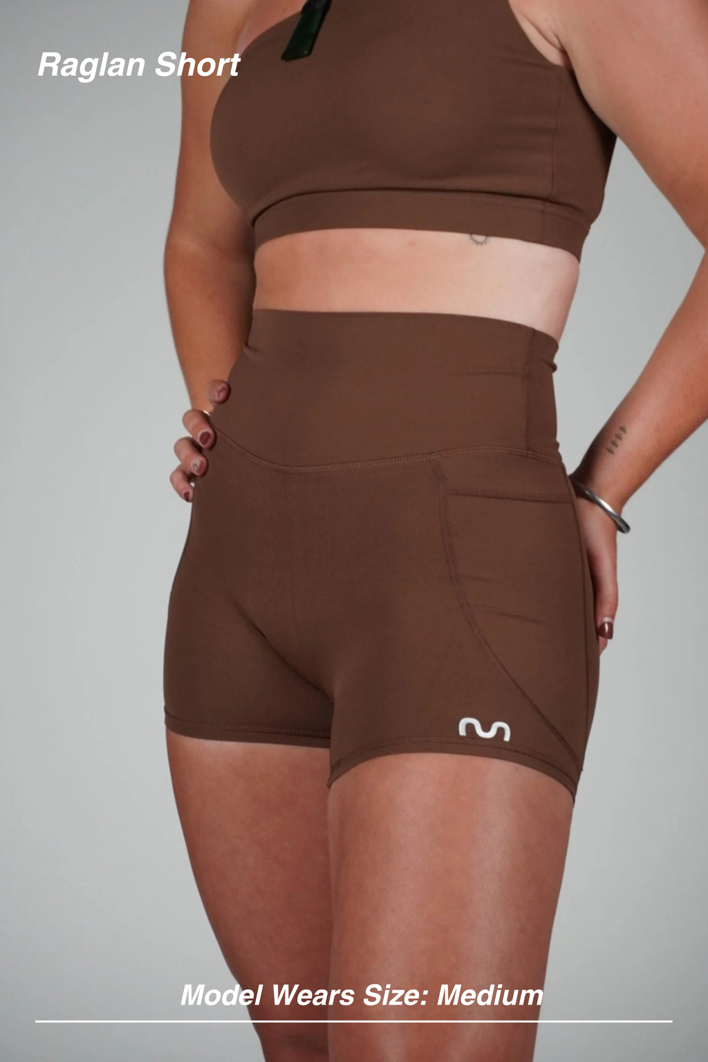 Mint Activewear Raglan Short in chocolate brown, front side close-up showing the high waistband and side pocket.