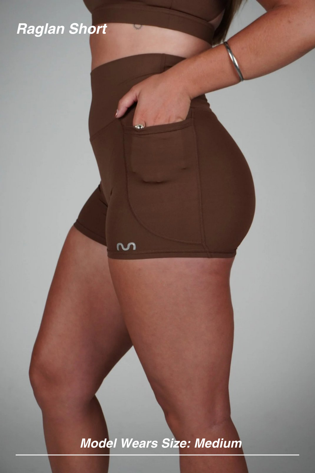 Mint Activewear Raglan Short in chocolate brown, side view with a hand resting in the open side pocket.