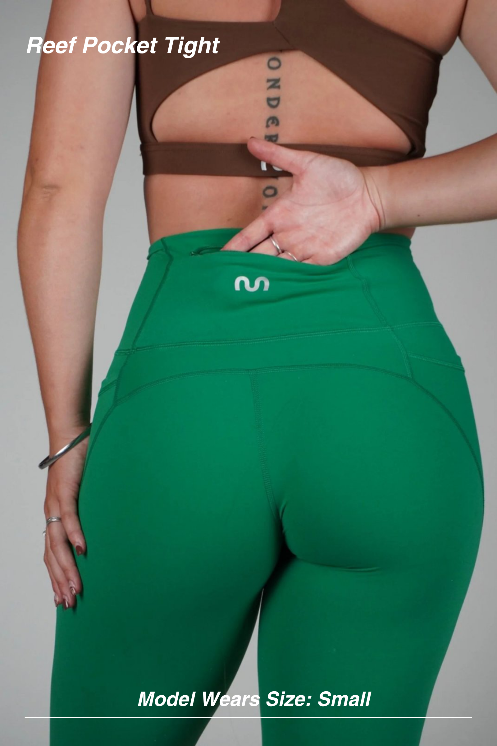 Mint Activewear Reef Pocket Tight in green, close-up of the back waistband with a hand tucked into the side pocket.