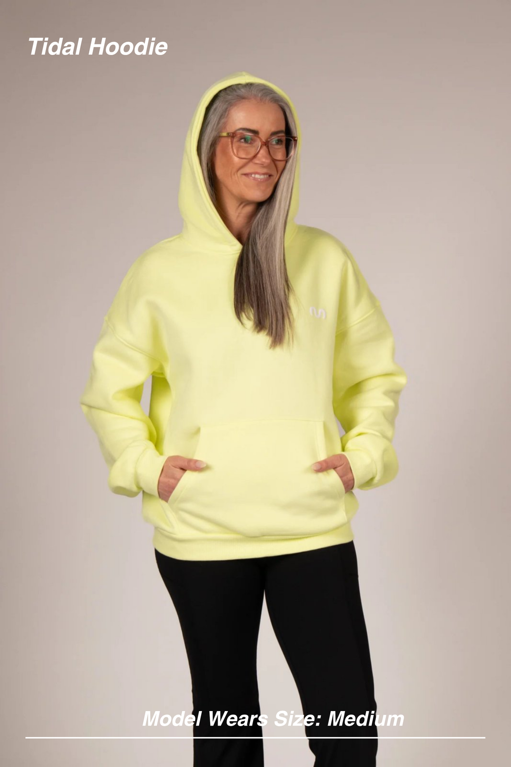 Mint Activewear Tidal Hoodie in yellow, front view with hands in the kangaroo pocket and a small chest logo.