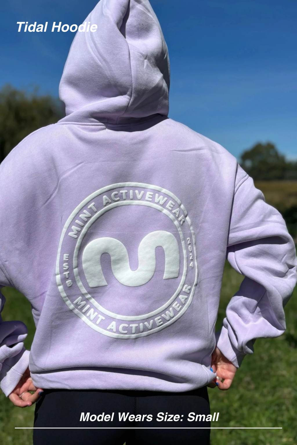 Mint Activewear Tidal Hoodie in lilac, back view outdoors with the large tonal circular logo print.