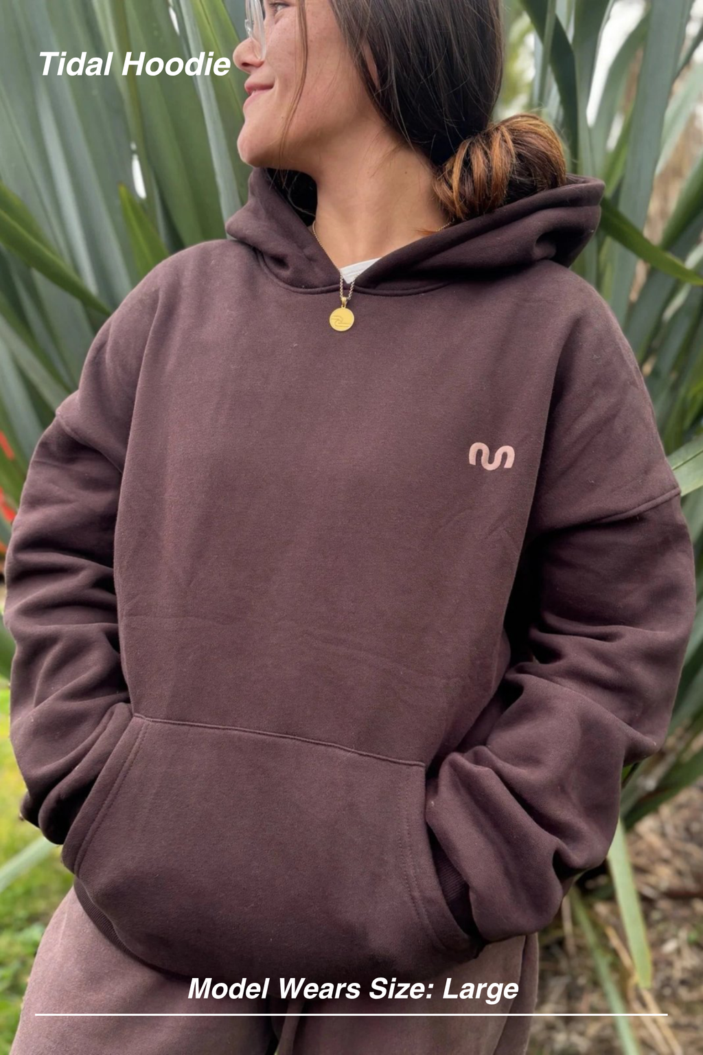 Mint Activewear Tidal Hoodie in chocolate, front view with the hood up and a small chest logo, shot outdoors.