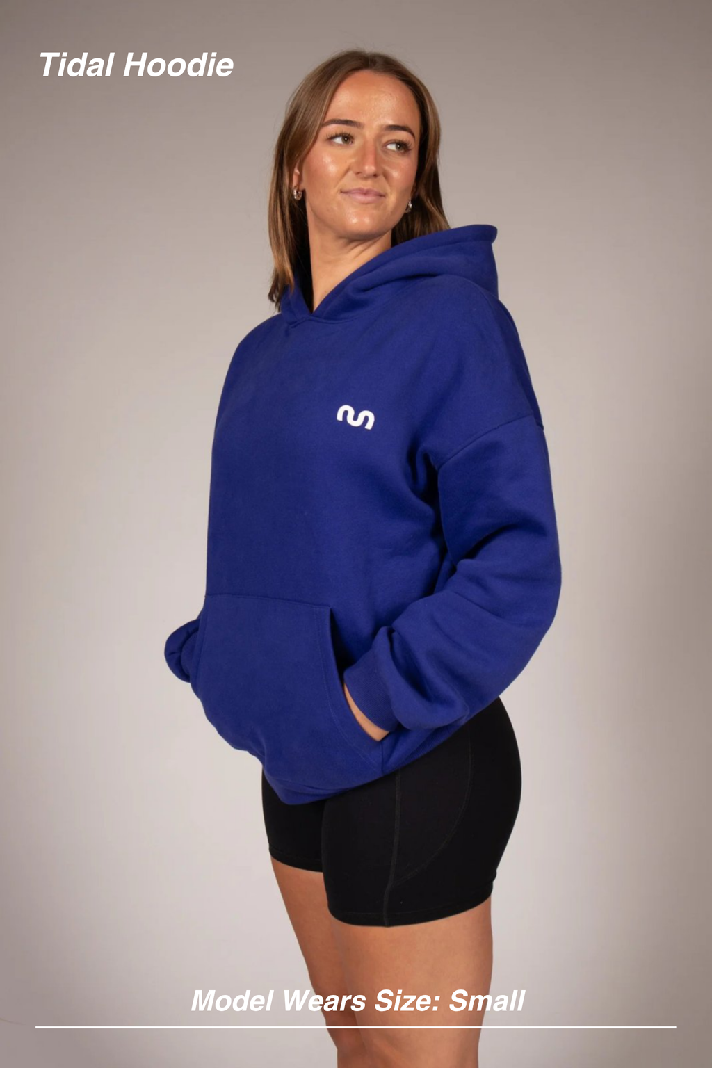Mint Activewear Tidal Hoodie in blue, side view with a hand in the kangaroo pocket and small chest mark.